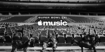 Super Bowl LXI Jay-Z: the rapper sits in camouflage clothing on an empty stadium stand among black goats, below the Apple Music Halftime Show logo