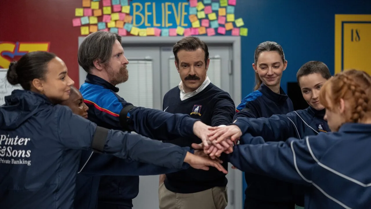 Ted Lasso season 5: Ted Lasso joins hands with the AFC Richmond women's team beneath the Believe sign